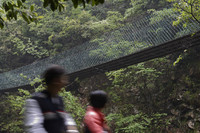 People Walking under a Hanging Bridge in China